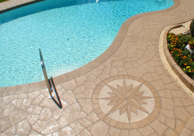 Pool deck with compass design in stamped concrete.